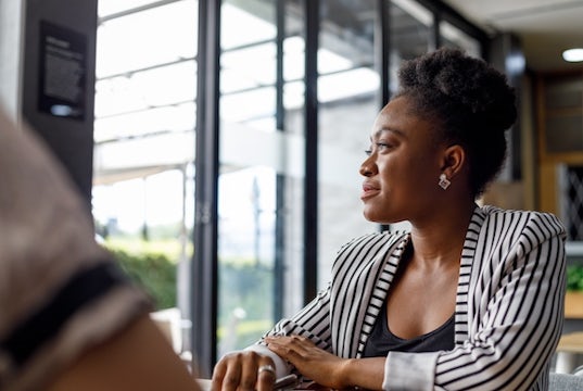 entrepreneur gazes out the window considering her business plans