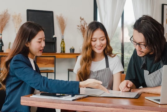 A tax professional meets with the owners of a small coffee shop