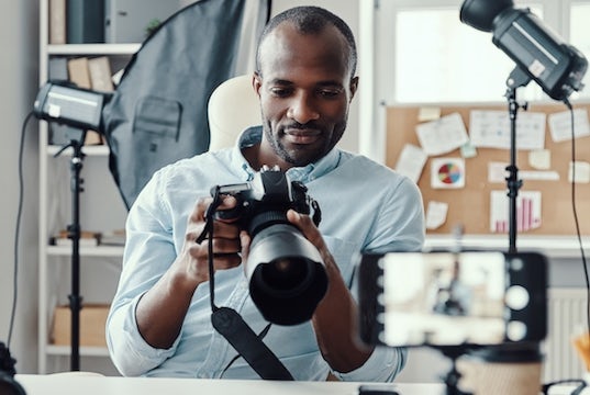 photographer looks at his camera