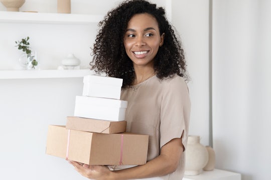 A woman carries boxes she's packed with orders from her online store