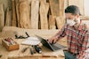 Carpenter business owner uses his laptop in his workshop to file a Beneficial Owner Information Report