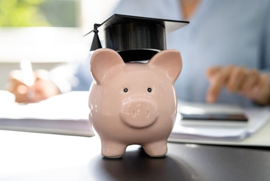 A piggy bank wearing a mortarboard graduation hat 