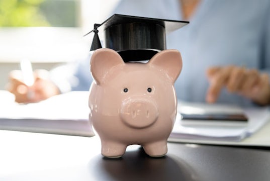 A piggy bank wearing a mortarboard graduation hat