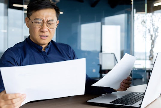 Businessman is frustrated and confused as he reviews his tax bill