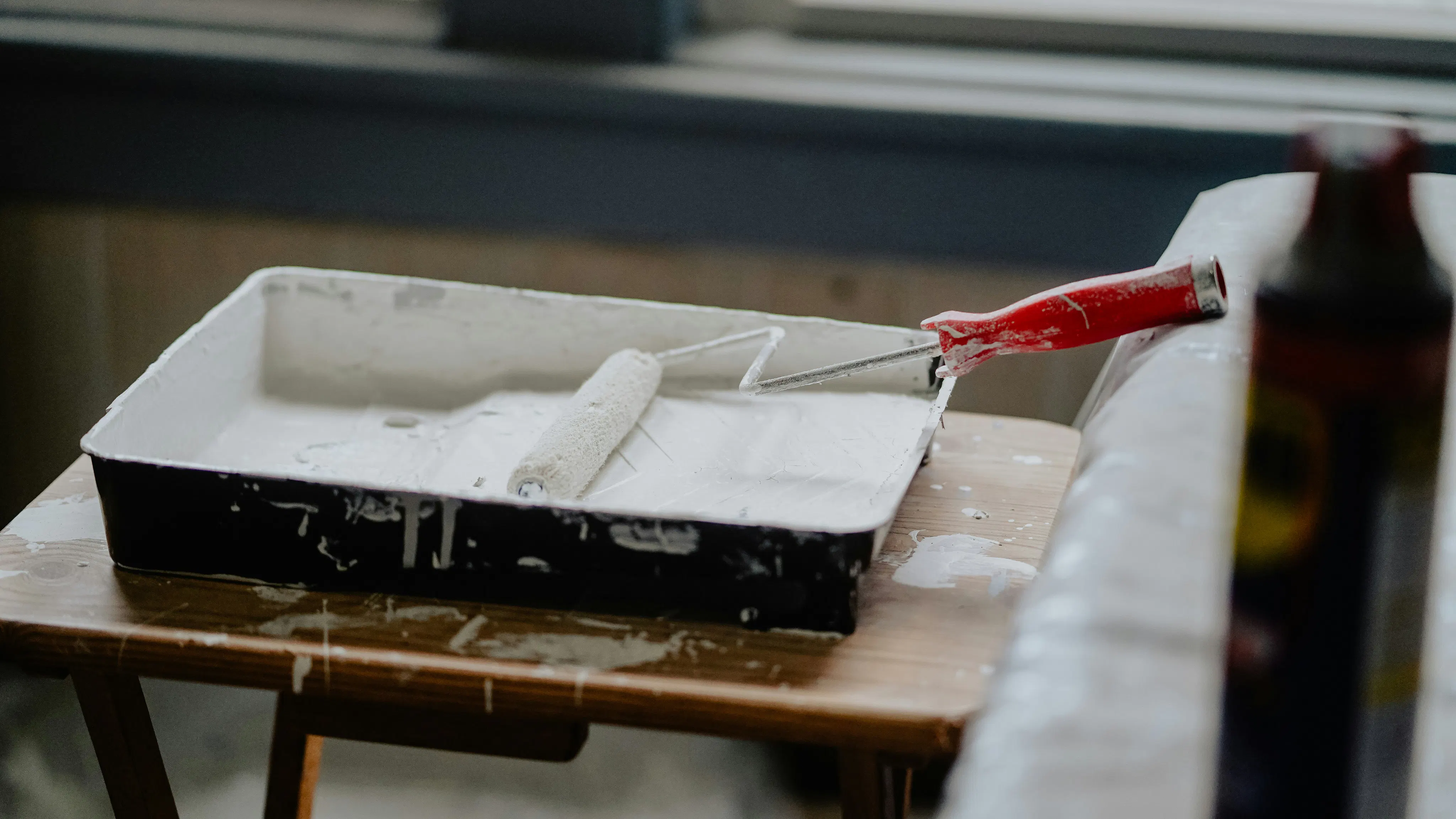 Paint roller in pan on table