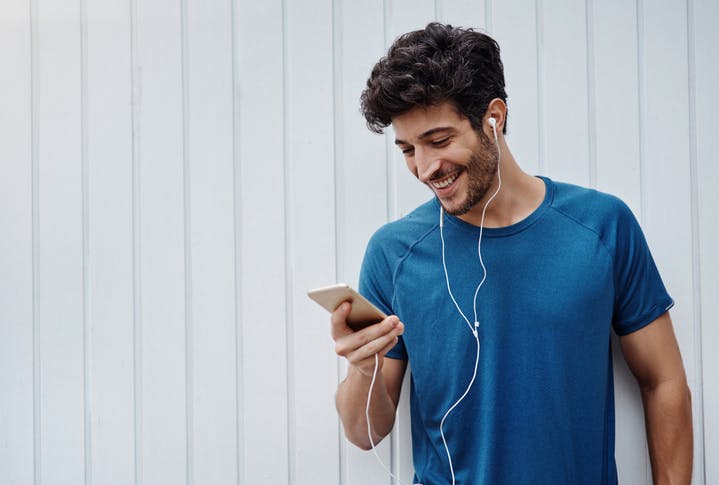 Homem ouvindo música e mexendo no celular
