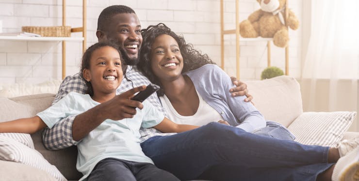 Família se diverte enquanto assiste TV