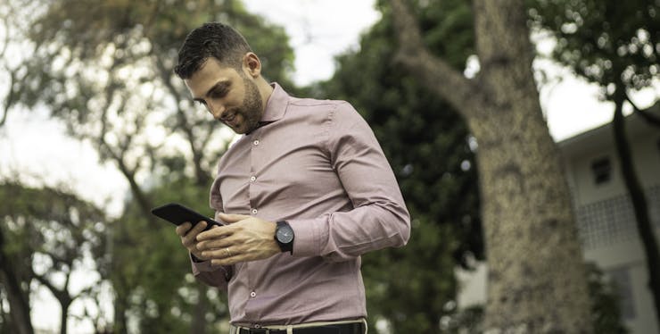 Homem usando o celular para saber o número da Claro