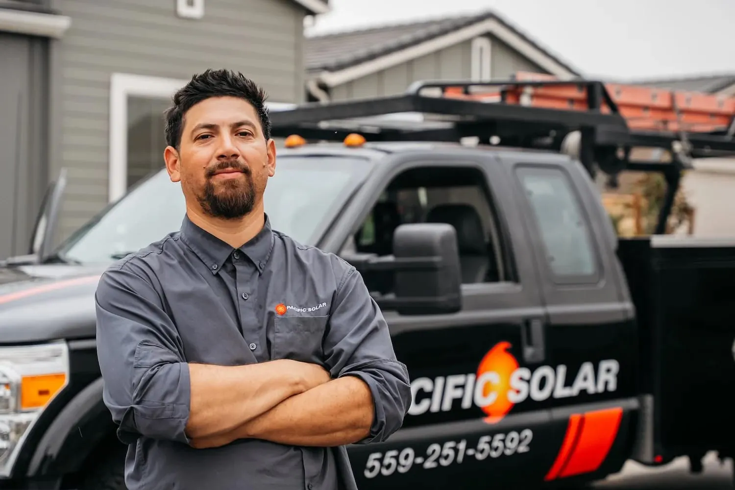 A solar installation crew member standing in front of his truck, branded with Pacific Solar company name.