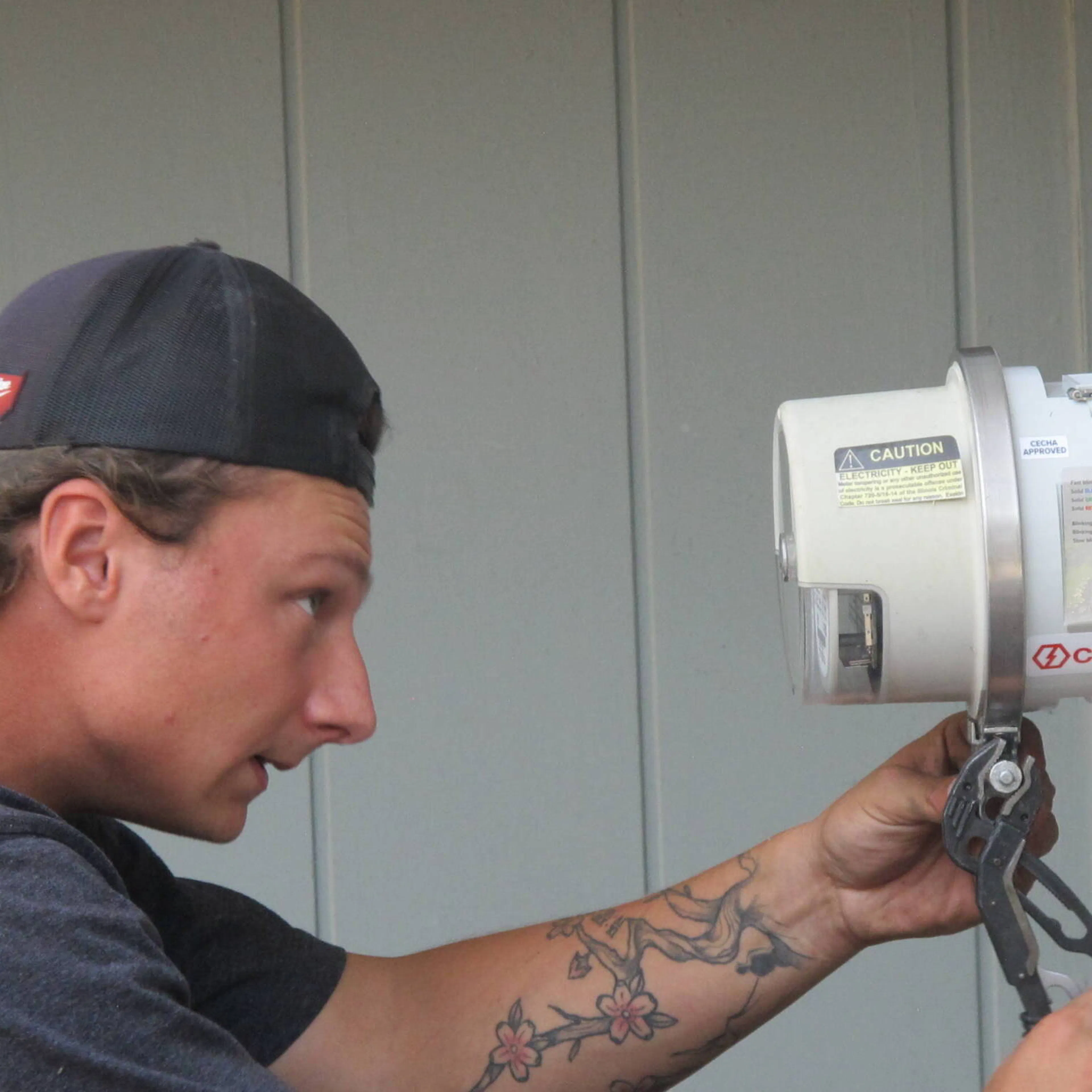 An electrician from Sparc Solar and EV Solutions installing a ConnectDER EV Meter Socket Adapter on a home.