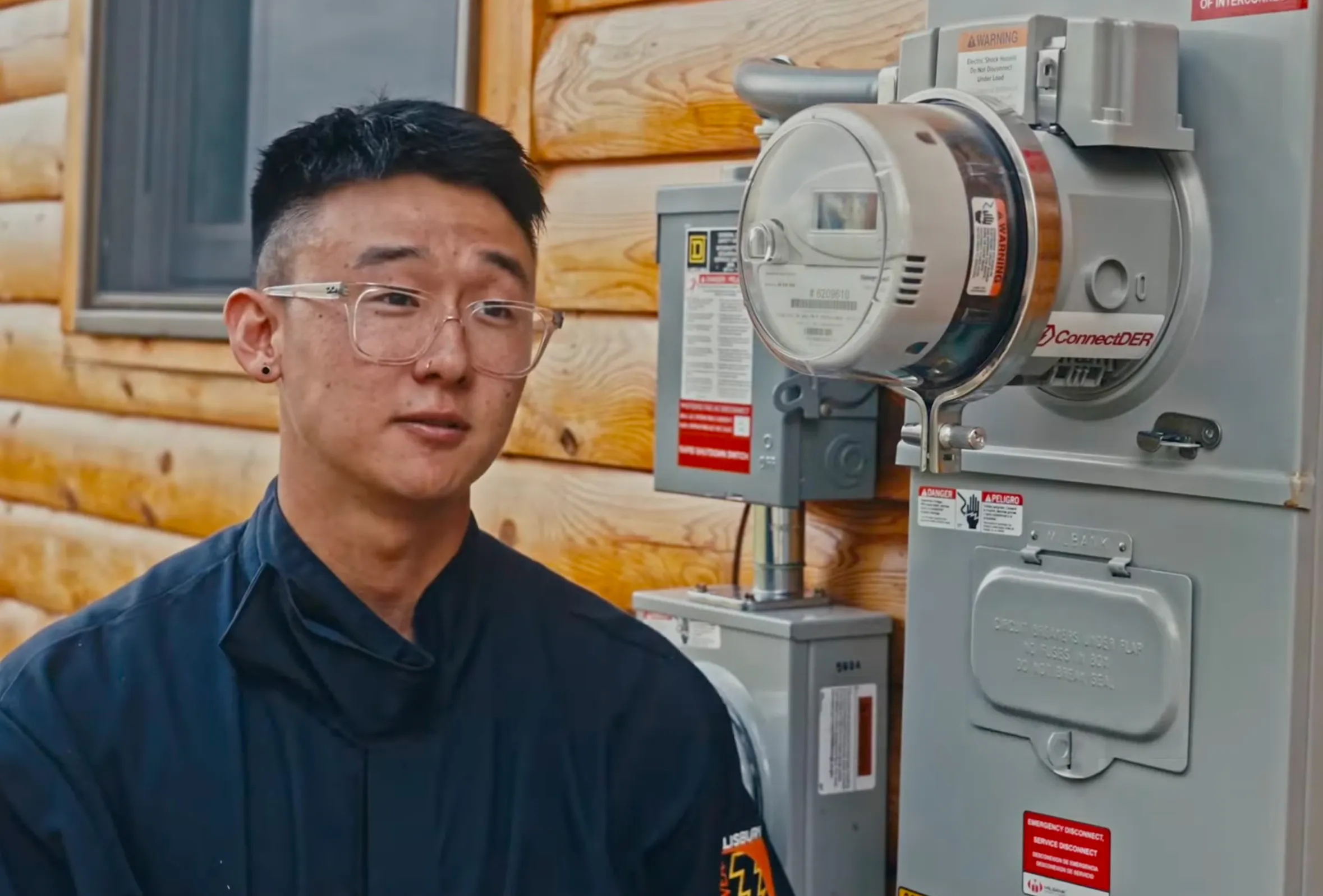 A crew member of Green Mountain Solar standing in front of a home's meter socket, with the ConnectDER Solar MSA installed behind the utility meter.