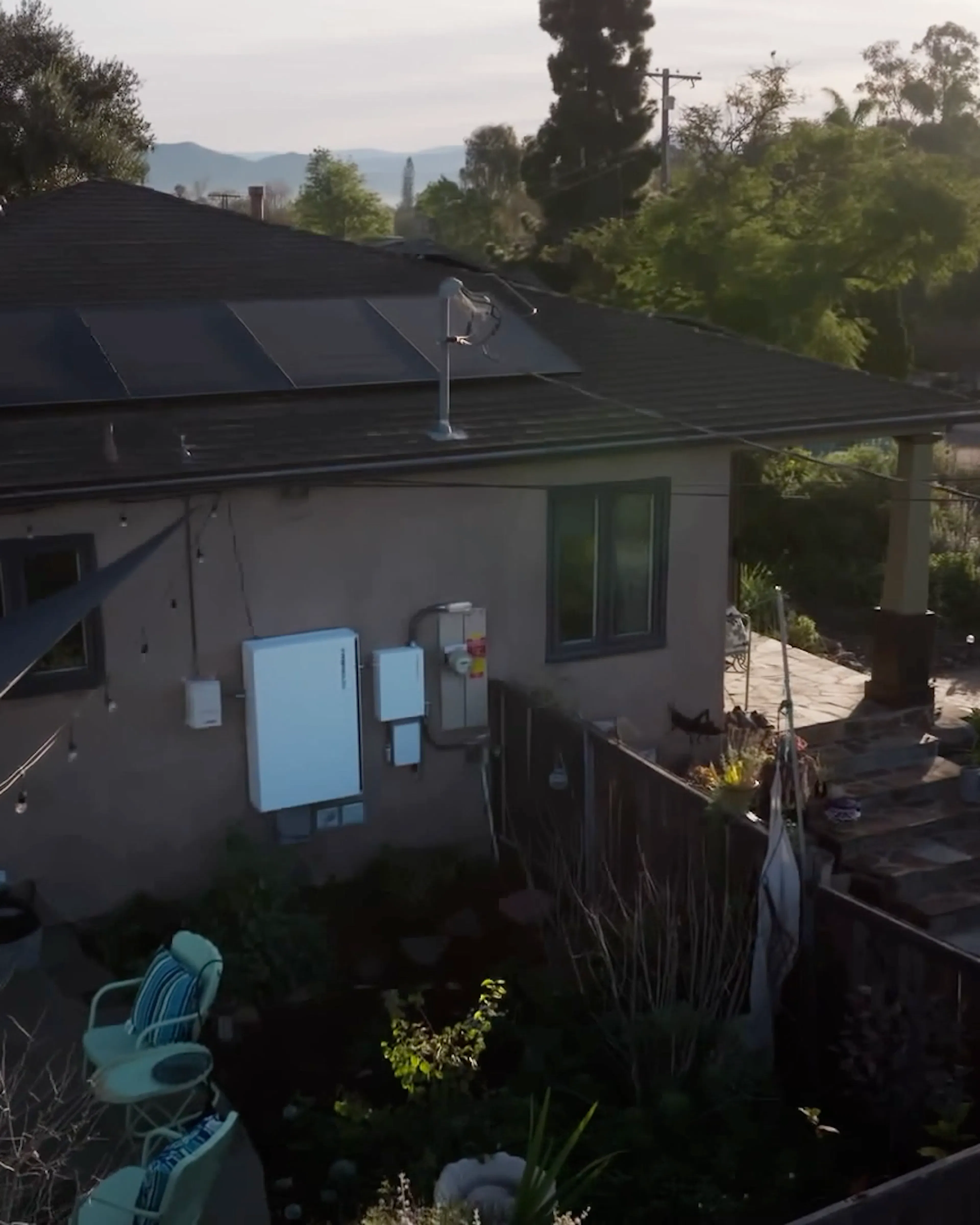 The side of a home in California with an energy storage system on the wall connected to a ConnectDER IslandDER™ Meter Socket Adapter.