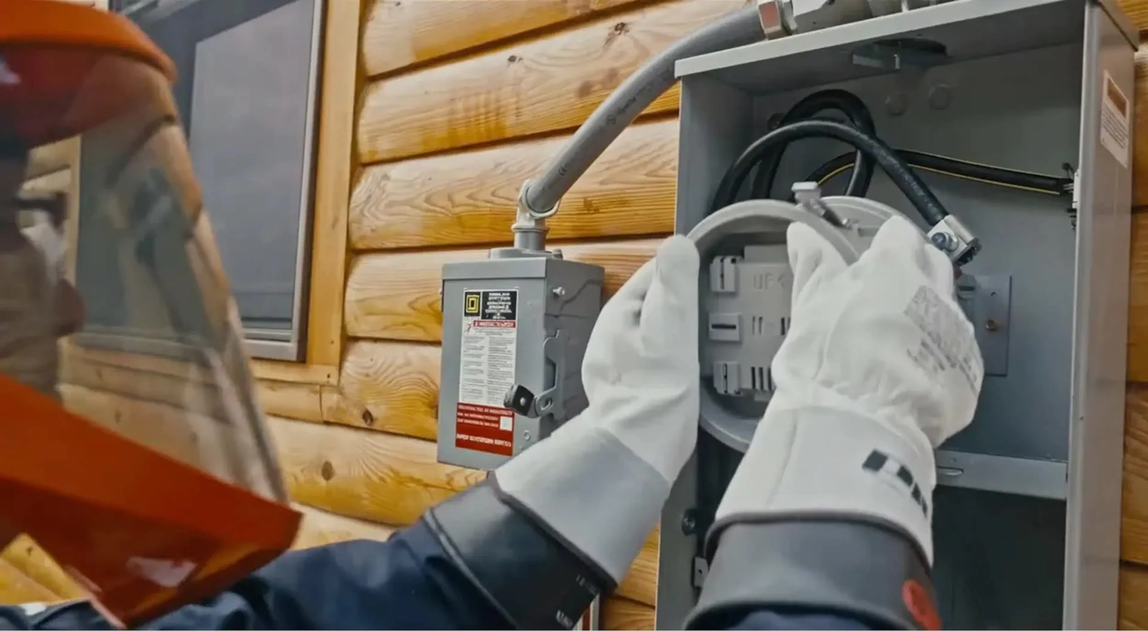 An electrician inserting a ConnectDER meter socket adapter into a home's meter socket during a solar installation.