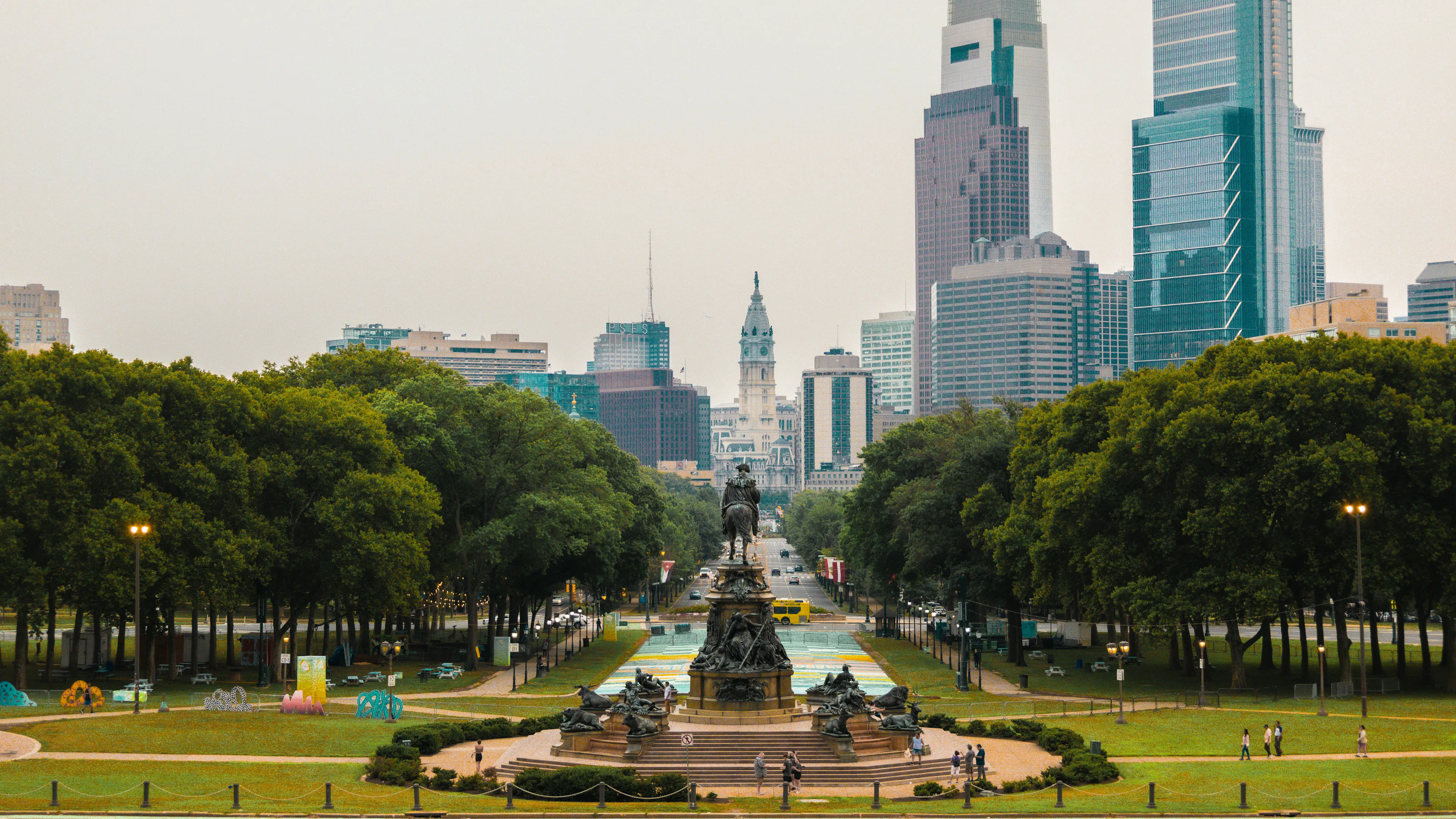 Image of the Philadelphia skyline with tall buildings, the liberty bell, and the famous statue.