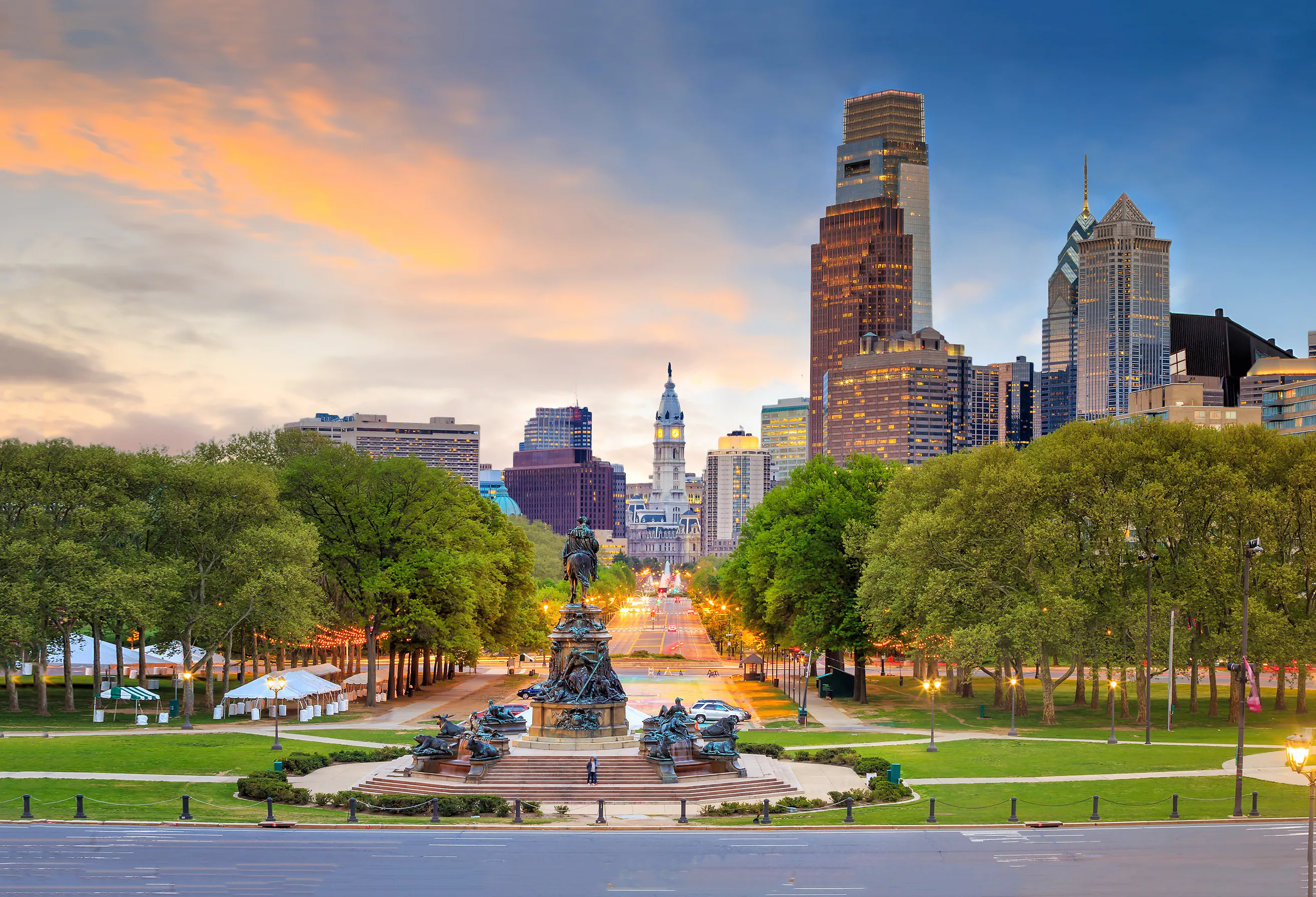 Image of the Philadelphia skyline with tall buildings, the liberty bell, and the famous statue.
