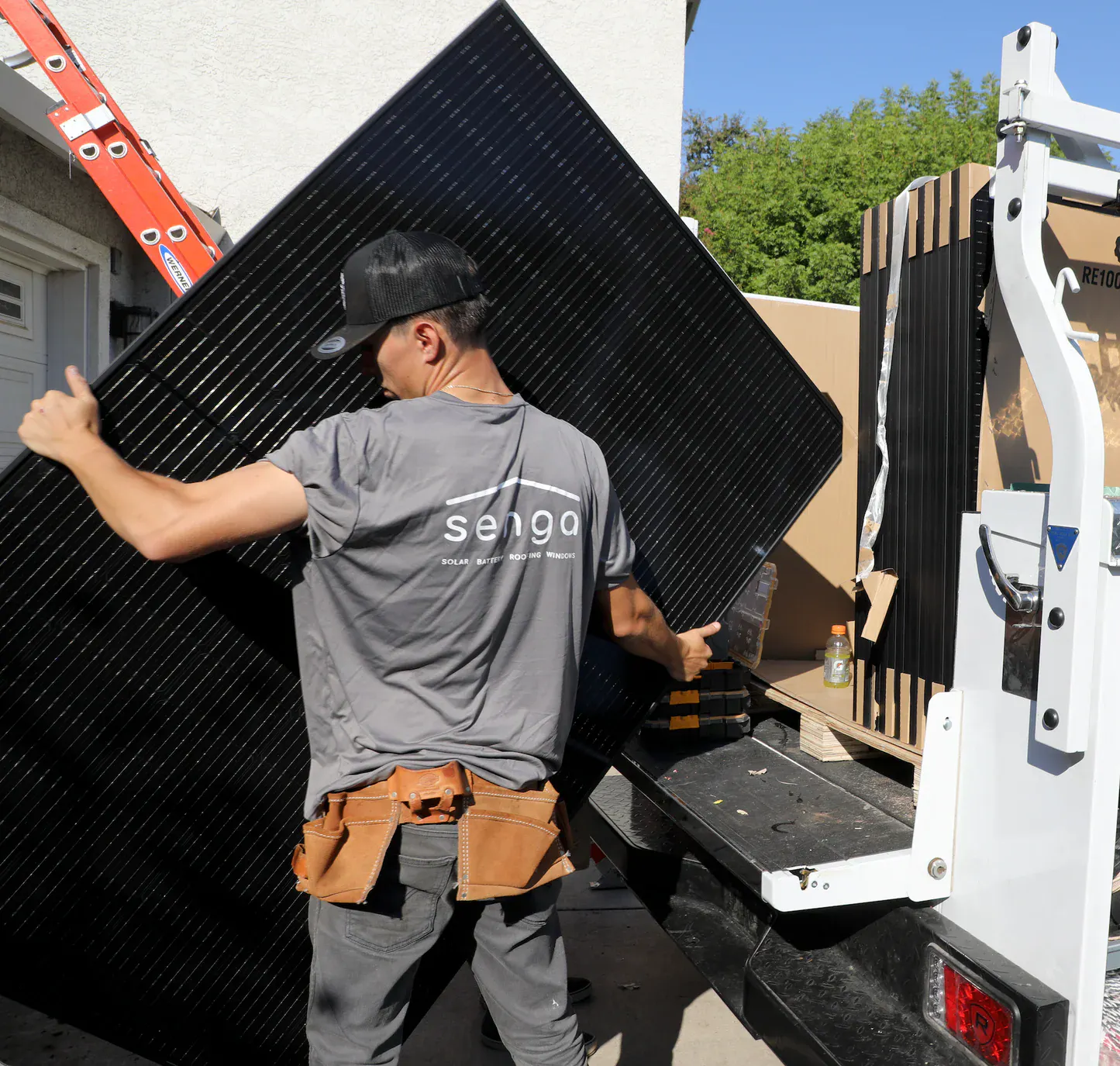 A installation crew member of Senga Energy in California carrying a solar panel.