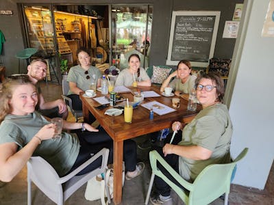A group of volunteers sit around a table at a cafe