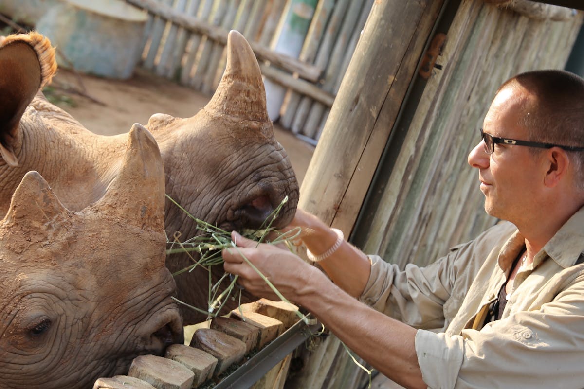 Martin and Julie While: Martin feeding rhinos at Care for Wild