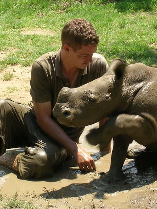 An ACE volunteer with an orphaned rhino at Moholoholo