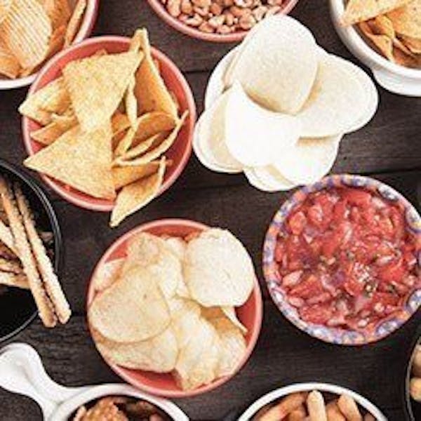 Lots of snack items in bowls on a table