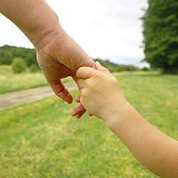 A child and parent holding hands