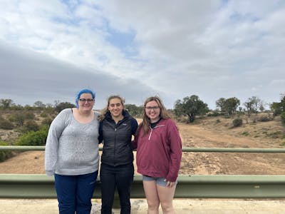 Kaitlyn Evans: a group of female students posing in front of a landscape