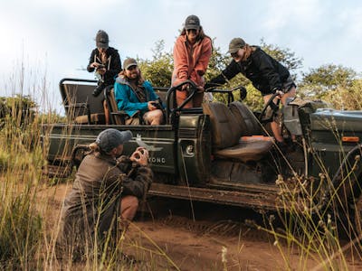 Group of ACE students posing atop a vehicle