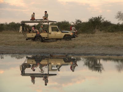 ACE volunteers inside the vehicle and on top of it, next to water to view wildlife