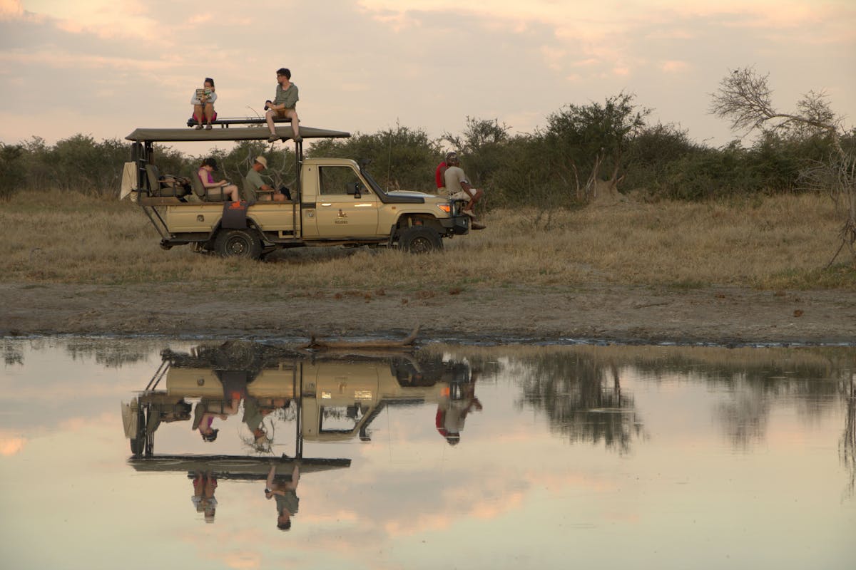 ACE volunteers inside the vehicle and on top of it, next to water to view wildlife