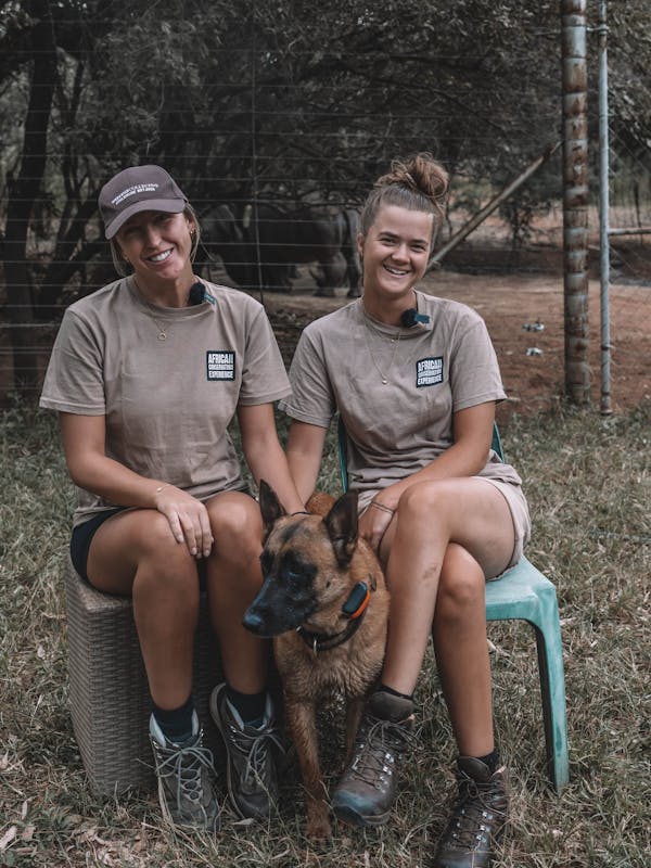 Two girls with anti-poaching dog, at The Rhino Orphanage