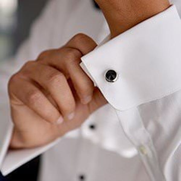 A man fastening his shirt cufflinks