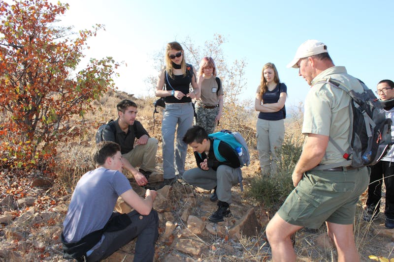 A school group learning about tracking in the African bush