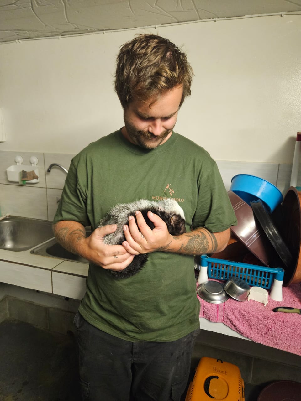 Sam Duggan: male volunteer holding baby 