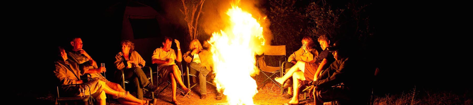 Group of ACE volunteers relaxing around the campfire