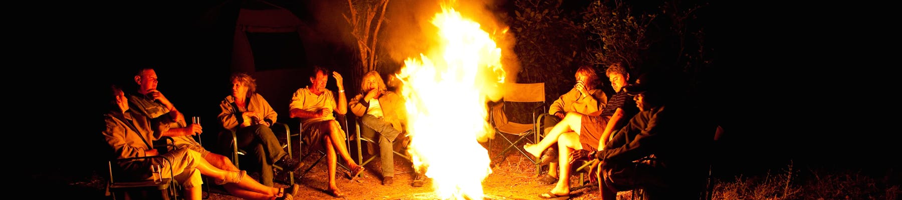 Group of ACE volunteers relaxing around the campfire