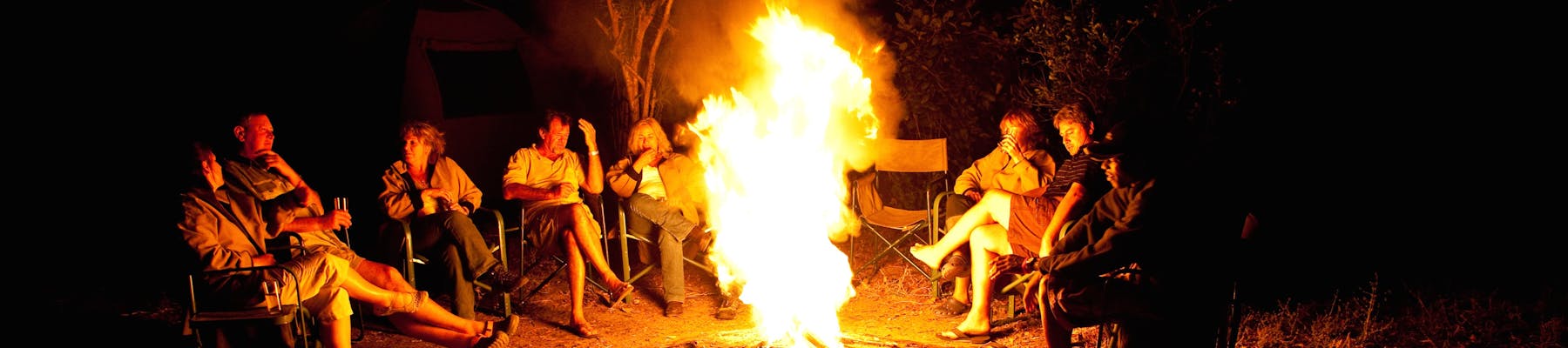 Group of ACE volunteers relaxing around the campfire