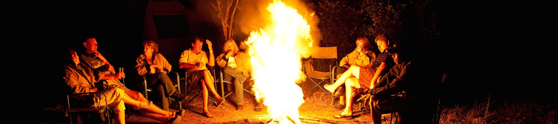 Group of ACE volunteers relaxing around the campfire