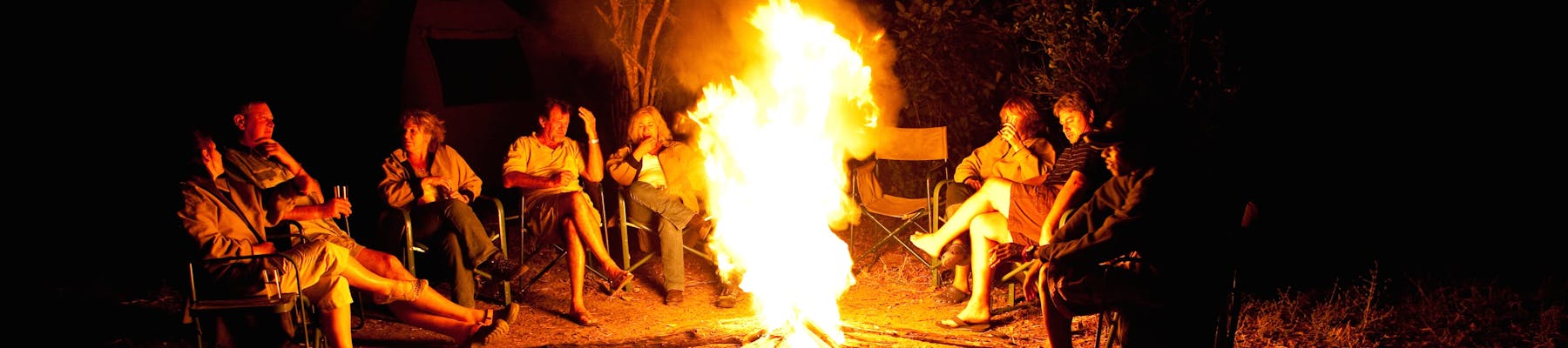 Group of ACE volunteers relaxing around the campfire