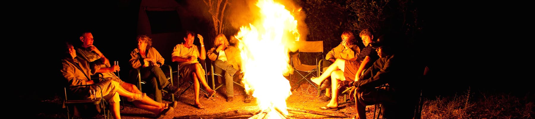 Group of ACE volunteers relaxing around the campfire