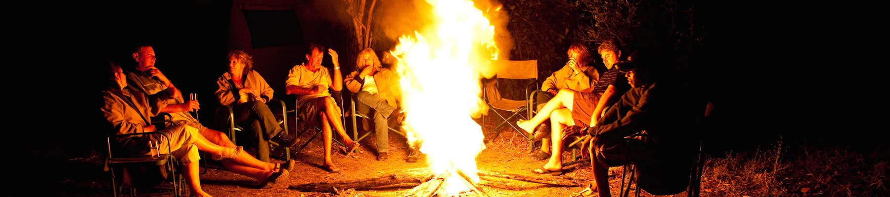 Group of ACE volunteers relaxing around the campfire