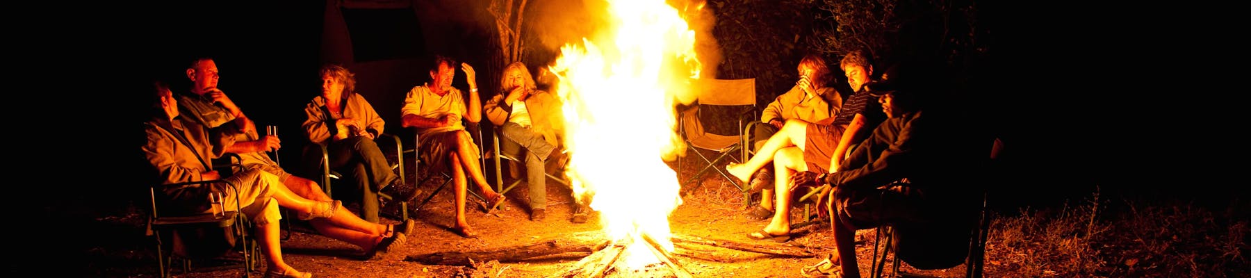 Group of ACE volunteers relaxing around the campfire