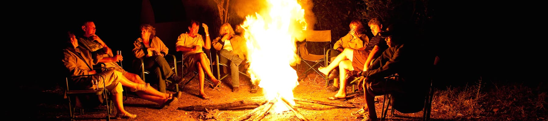 Group of ACE volunteers relaxing around the campfire