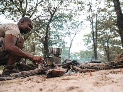 Professional guide cooking over a campfire in the Okavango 