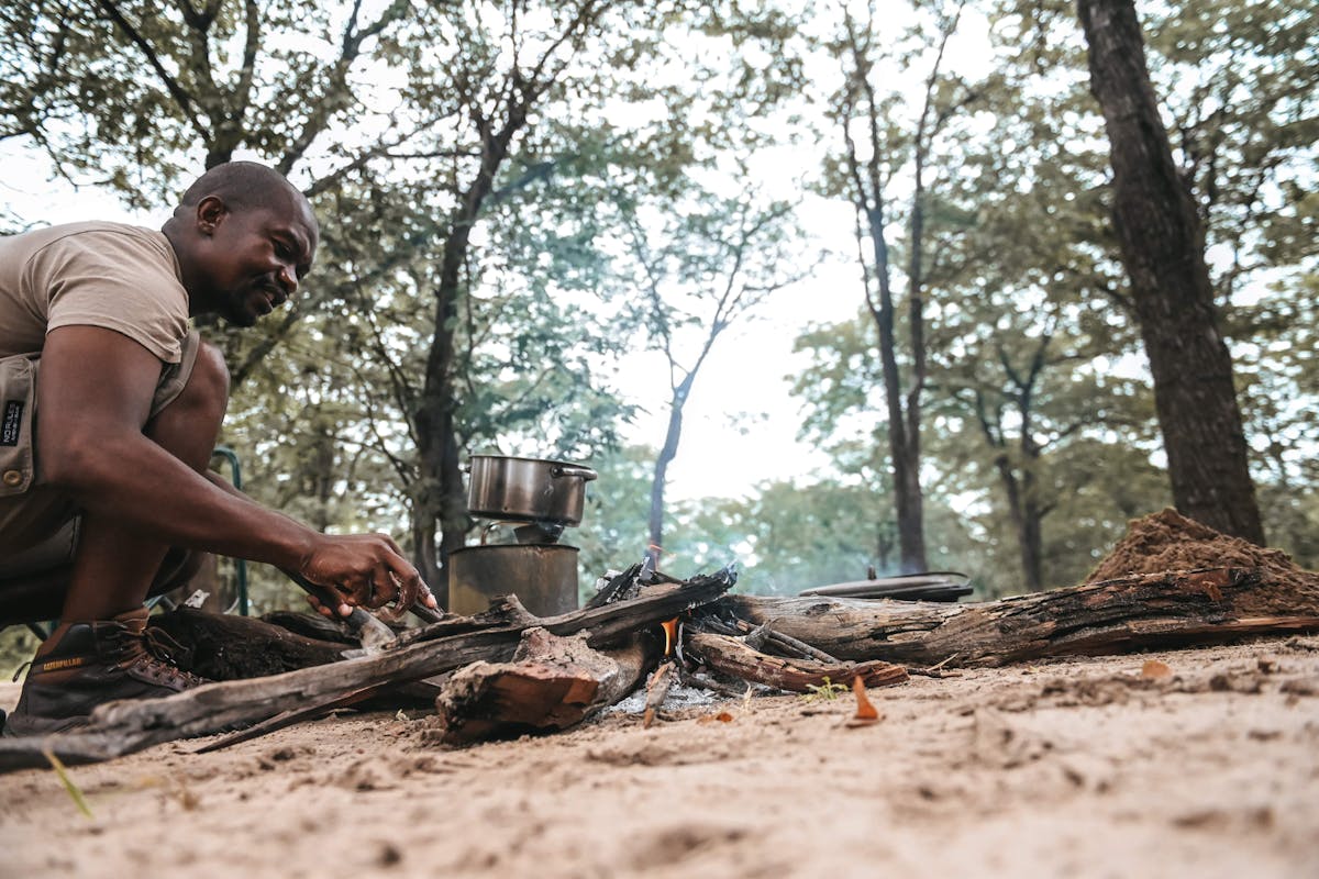 Professional guide cooking over a campfire in the Okavango 