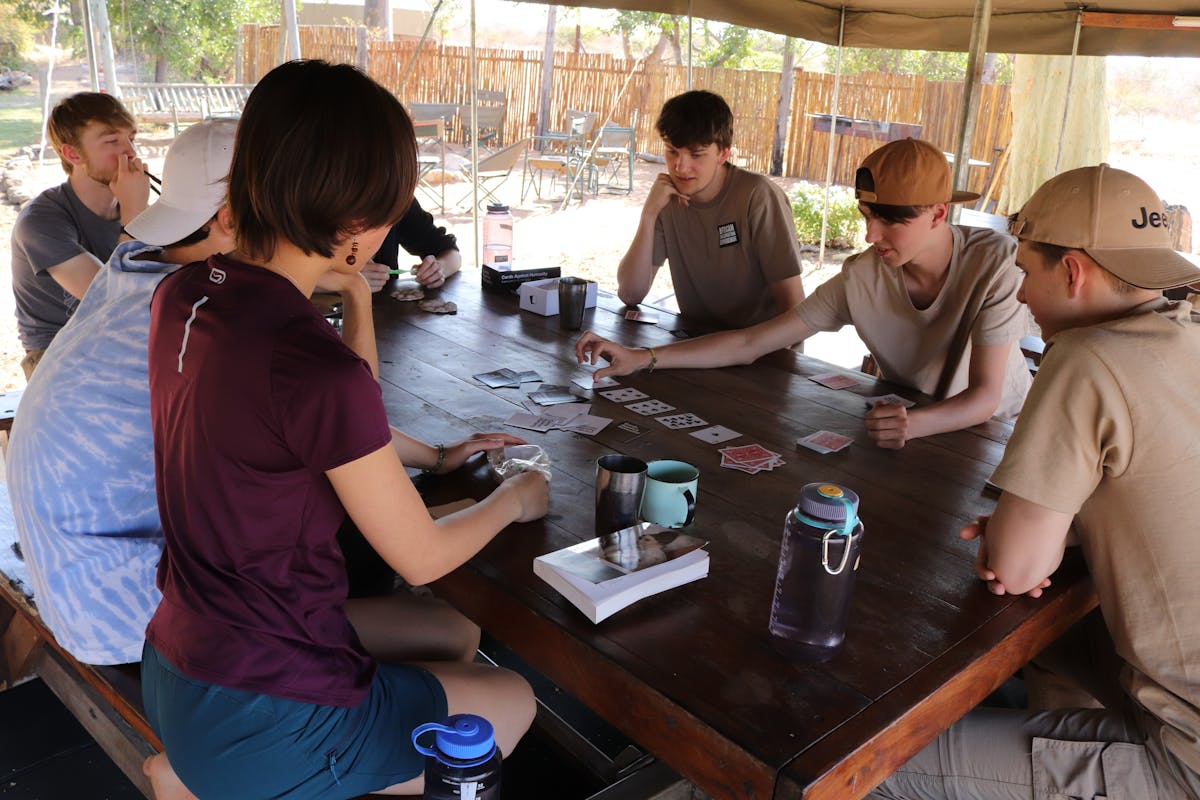 ACE group of students relaxing in their accommodation, playing a card game