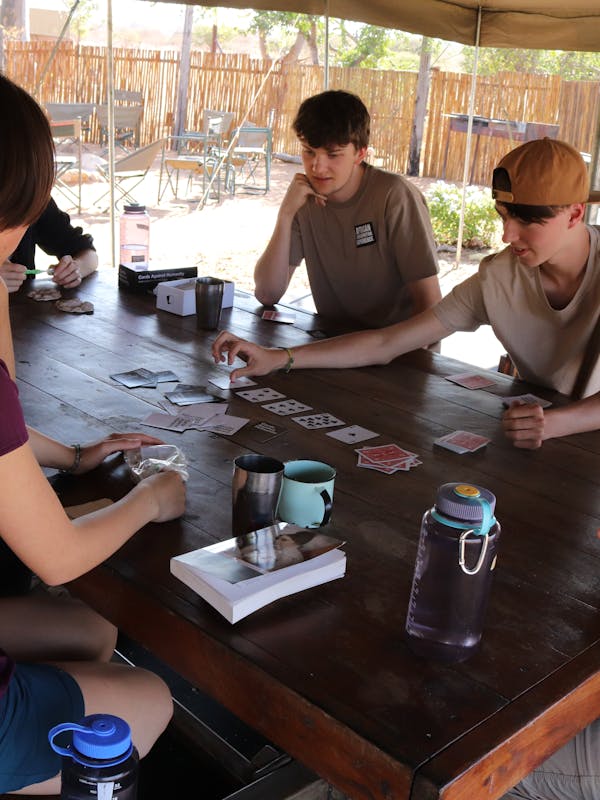 ACE group of students relaxing in their accommodation, playing a card game