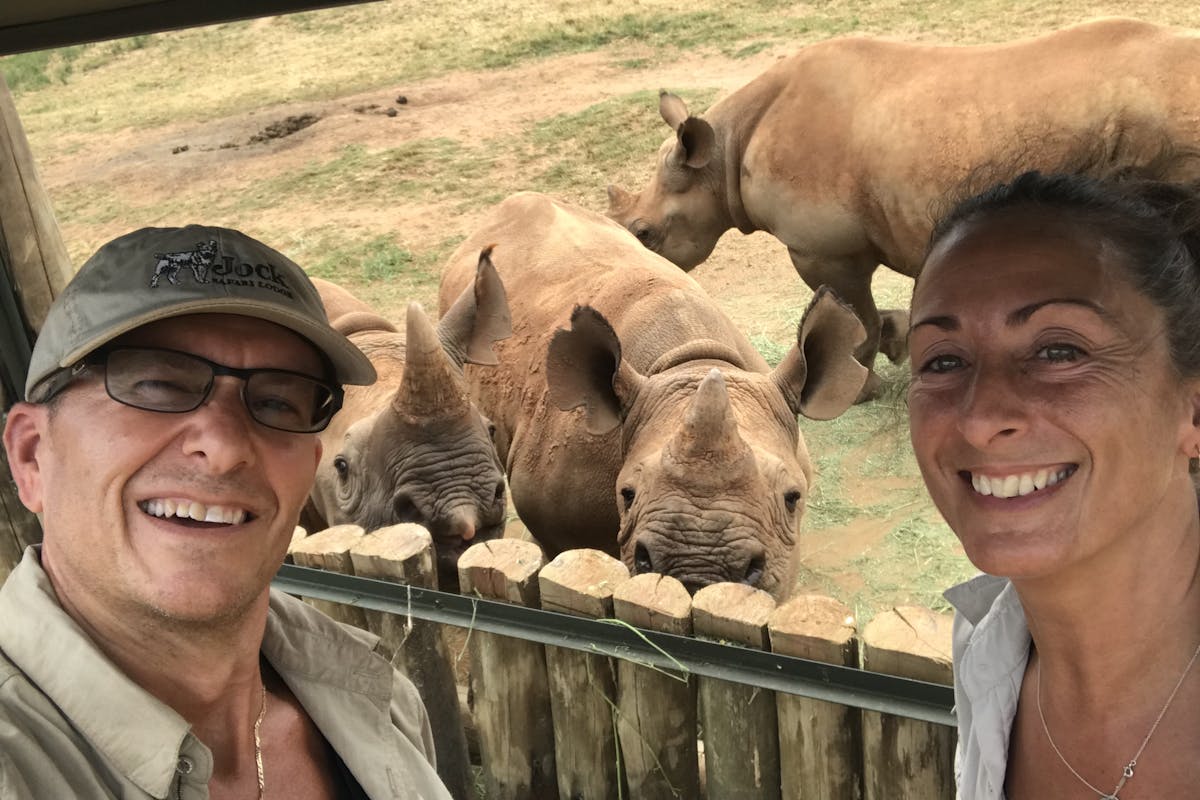 Martin and Julie While: posing with rhinos in the background