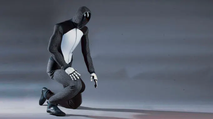 Photograph of Figure's humanoid robot kneeling on one knee against a grey backdrop