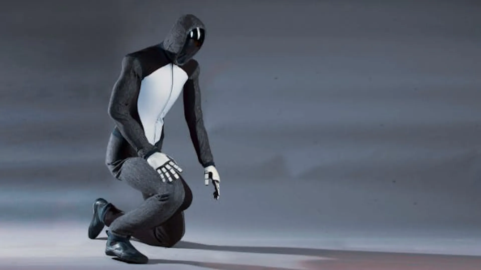 Photograph of Figure's humanoid robot kneeling on one knee against a grey backdrop
