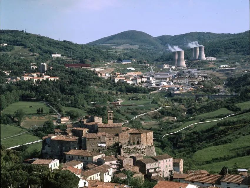 Photograph of the Larderello geothermal plant in Tuscany, cooling towers rising above a hillside village